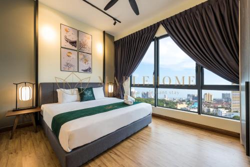 - une chambre avec un grand lit et de grandes fenêtres dans l'établissement The Apple Premier Suites Melaka, à Malacca