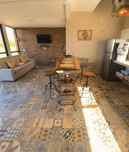 a living room with a table and a refrigerator at NATIVOS DE MINAS in Santana do Riacho
