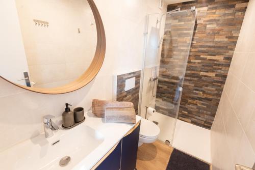 une salle de bain avec un lavabo et un miroir et des toilettes dans l'établissement Elegant T3 entre Gare et Coeur de ville par Groom*, à Lorient