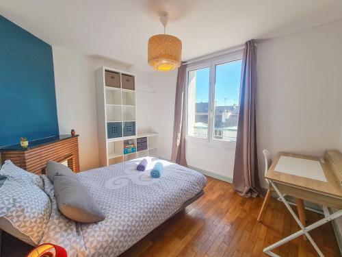 une chambre avec un lit, une table et une fenêtre dans l'établissement Elegant T3 entre Gare et Coeur de ville par Groom*, à Lorient