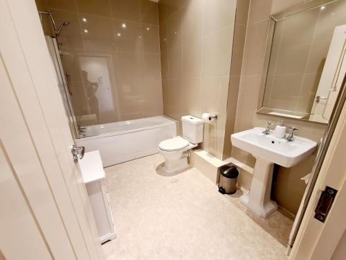 a bathroom with a sink and a toilet and a bath tub at Vitamin Sea Beachfront Apartment Ramsgate - Sleeps 4 in Ramsgate
