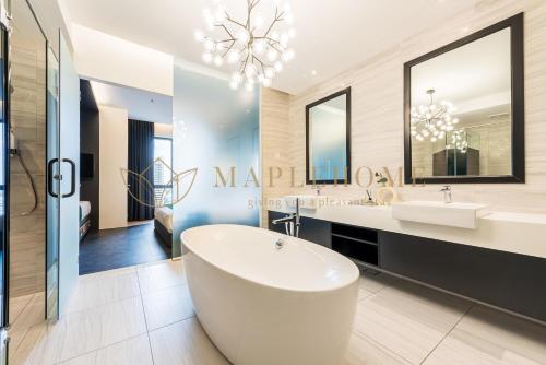 een grote badkamer met een bad en een wastafel bij The Apple Premier Suites Melaka in Melaka