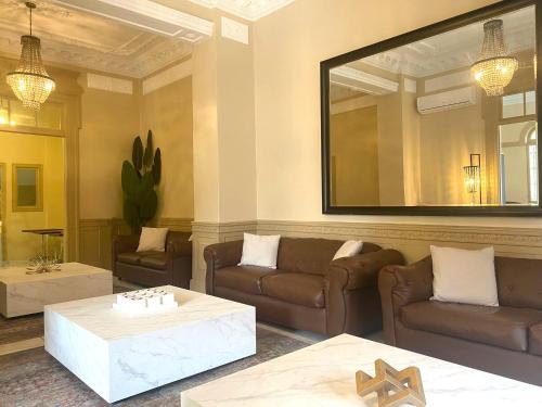 a living room with couches and a large mirror at Magnolia Inn in Panama City