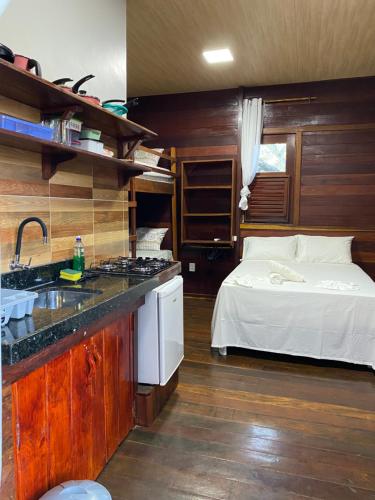 a kitchen with a bed and a sink in a room at Chalés Paradise in Atins