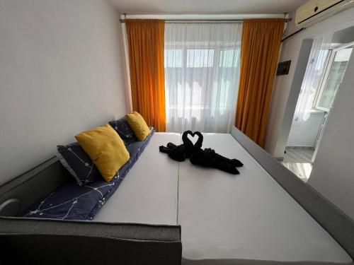 a bed with a pair of black shoes sitting on it at Miha modern and central apartament in Arad
