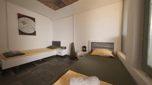 a bedroom with a bed and a bench on the wall at Hostel Dera in Pristina