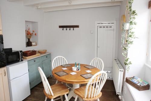 - une cuisine avec une table et des chaises en bois dans l'établissement Millgate Cottage in the heart of Richmond, à Richmond