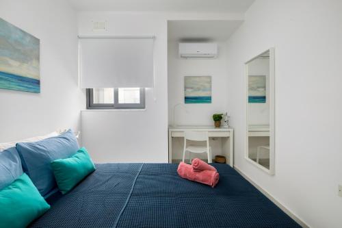 Cette chambre comprend un lit avec une serviette rose. dans l'établissement Cosy, Modern 1 Bedroom Apartment (Qawra), à San Pawl il-Baħar