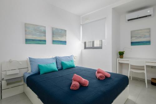 - une chambre avec un lit et des serviettes roses dans l'établissement Cosy, Modern 1 Bedroom Apartment (Qawra), à San Pawl il-Baħar