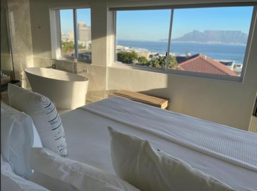 a hotel room with two beds and a window at Gull on the Bay Boutique Guest House in Bloubergstrand