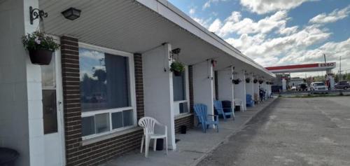 a building with chairs and a gas station at Regal Motel in Timmins