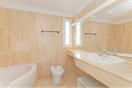 a bathroom with a sink and a tub and a toilet at Apartamento Sara en el Veril del Duque - Sara Vacation in Adeje