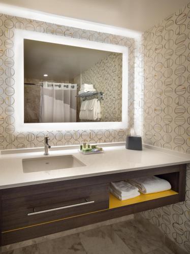 a bathroom with a sink and a mirror at Holiday Inn Montreal Longueuil by IHG in Longueuil