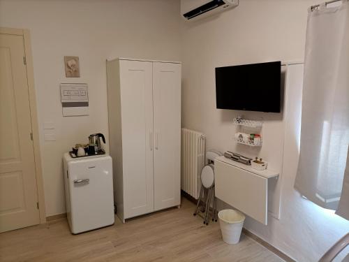 a room with a refrigerator and a tv on the wall at Affittacamere Il Chiostrino Guest House in Florence
