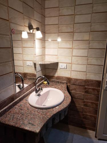 a bathroom with a sink and a mirror at Rahala Safari Hotel in Qasr Al Farafirah