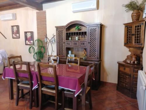 comedor con mesa y sillas de color púrpura en Casa rural Suerte de los Mozos, en Cáceres