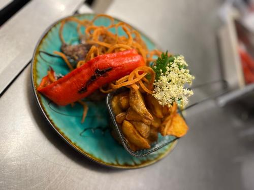 a plate of food with vegetables and chips on a table at Malom Club Panzió in Baja
