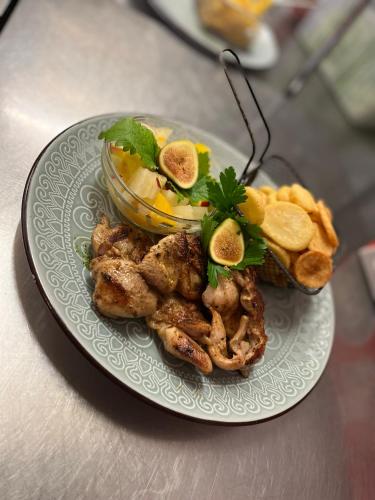 a plate of food with chicken and chips on a table at Malom Club Panzió in Baja