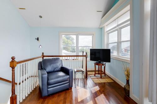 a living room with a chair and a television at Hampton Beach Beauty in Hampton