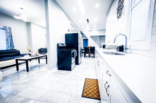 a kitchen with a sink and a living room at The Griffon House in Niagara Falls