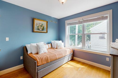 Cette chambre bleue comprend un lit et une fenêtre. dans l'établissement Hampton Beach Beauty, à Hampton Beach