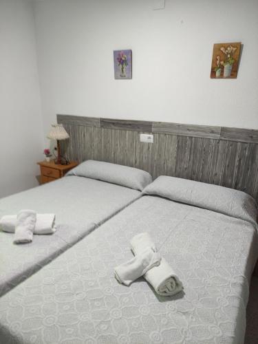1 dormitorio con 2 camas y toallas. en Hostal Restaurante Bar Cafeteria La Melchora en Posadas