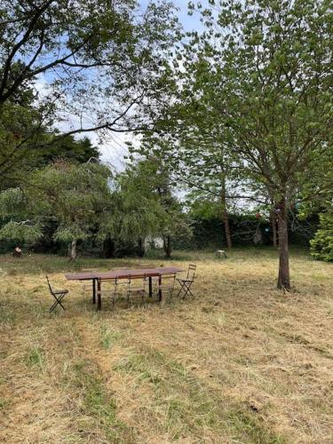 einen Picknicktisch auf einem Feld neben einem Baum in der Unterkunft Grande ferme à 50min de Paris in Le Plessis-Placy