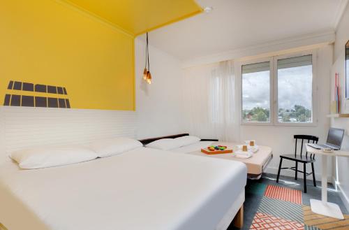 a hotel room with a bed and a desk at Hôtel ibis Styles Auxerre Nord in Auxerre