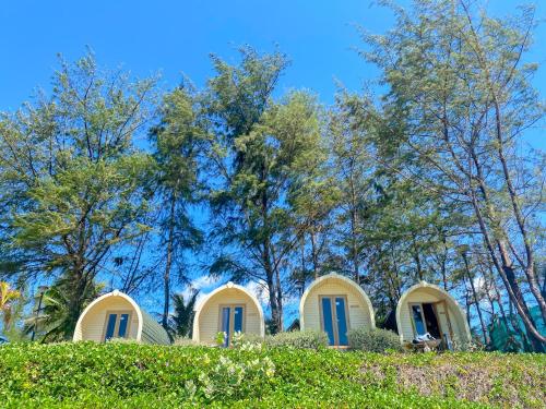 a house with blue doors on a hill with trees at Long Hải Channel Beach Resort in Long Hai