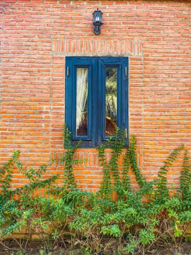 a blue window on a brick building with plants at Long Hải Channel Beach Resort in Long Hai