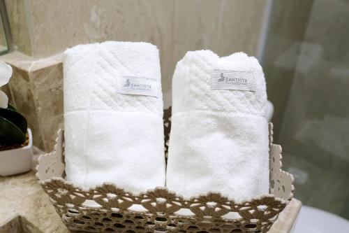 un par de toallas blancas en una cesta en un baño en Studio Manaíra #806 por Carpediem en João Pessoa