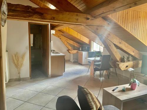 a living room with an attic with wooden ceilings at Super appartement loué meublé tout équipé in Saint-Claude