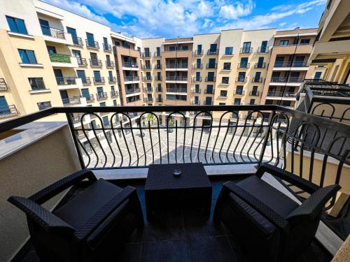 a balcony with two chairs and a table and some buildings at Green Hills by Rent a car MI in Podgorica