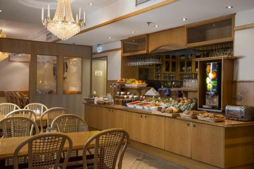 a restaurant with a buffet with tables and chairs at Crystal Plaza Hotel in Stockholm