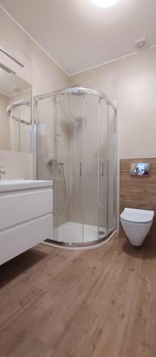 a bathroom with a shower and a toilet and a sink at Apartamenty ELIASZ in Ustronie Morskie