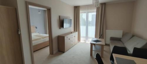 a small room with a bedroom with a bathroom at Apartamenty ELIASZ in Ustronie Morskie