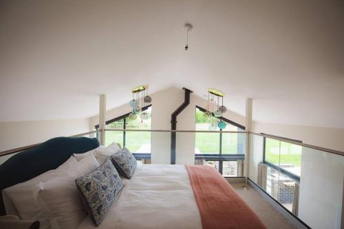 a bedroom with a bed and some windows at Holly Lodge and Little Orchard in Kingsdown
