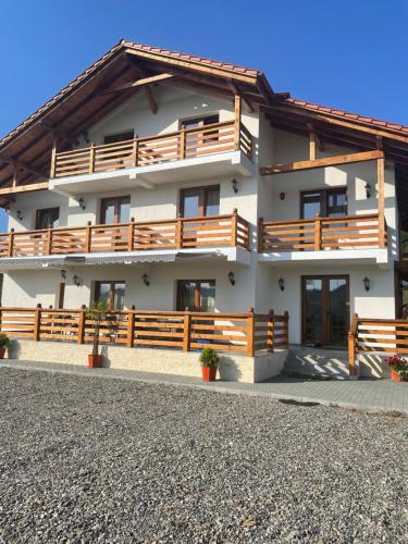 ein Haus mit Holzbalkonen und einem Zaun in der Unterkunft Pensiunea Sofia in Onceşti