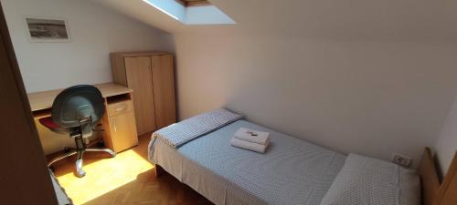 a bedroom with a bed and a desk and a chair at Apartma Ivan in Portorož