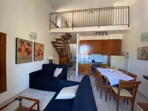 sala de estar y cocina con sofá azul y mesa en Mameli Suite en Spoleto