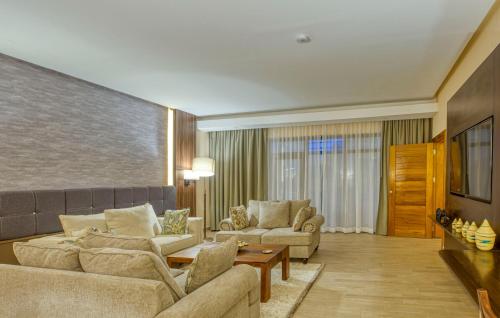 a living room with two couches and a table at Virunga Inn Resort & Spa in Kinigi