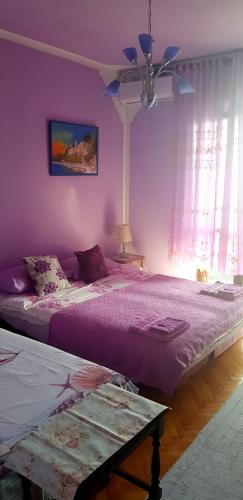 a purple bedroom with a bed and a ceiling at Guest House Cinderella in Herceg-Novi