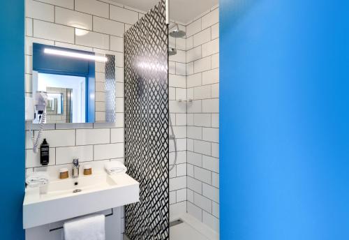 a bathroom with a sink and a mirror at Hôtel ibis Styles Auxerre Nord in Auxerre