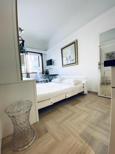 une chambre blanche avec un grand lit et une table dans l'établissement CosyGray512, à Cannes