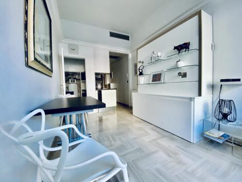 - un salon avec une table noire et des chaises blanches dans l'établissement CosyGray512, à Cannes