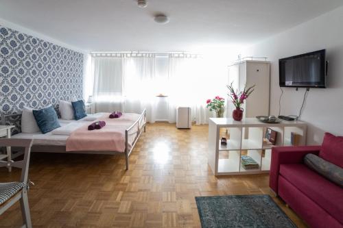 a living room with a bed and a couch at B&B MY PLACE mit Frühstückspaket - with Breakfastbox in Frankfurt/Main