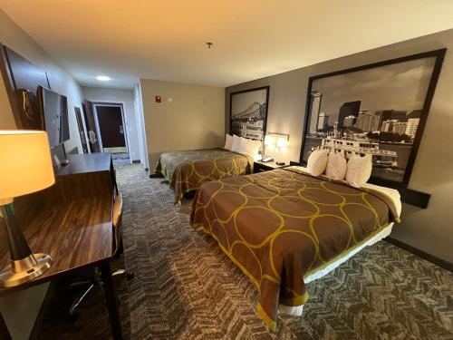 a hotel room with two beds and a desk at Super 8 by Wyndham Lake Charles/Sulphur in Lake Charles