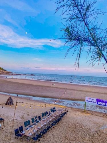 a beach with a row of chairs and the ocean at Long Hải Channel Beach Resort in Long Hai