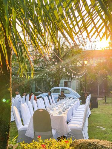 a long table with white chairs and a car at Long Hải Channel Beach Resort in Long Hai