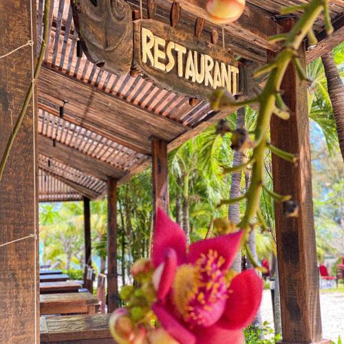 a pink flower in front of a resort sign at Long Hải Channel Beach Resort in Long Hai